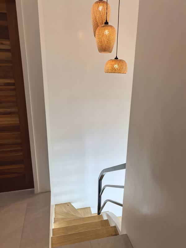 Floating wooden staircase with rattan pendants